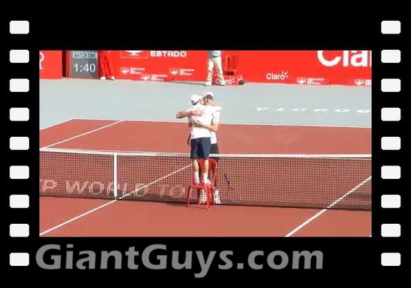 Dudi Sela uses a chair to hug Ivo Karlovic