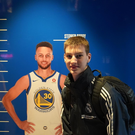 Olivier Rioux bending down next to 6ft3 NBA player Stephen Curry